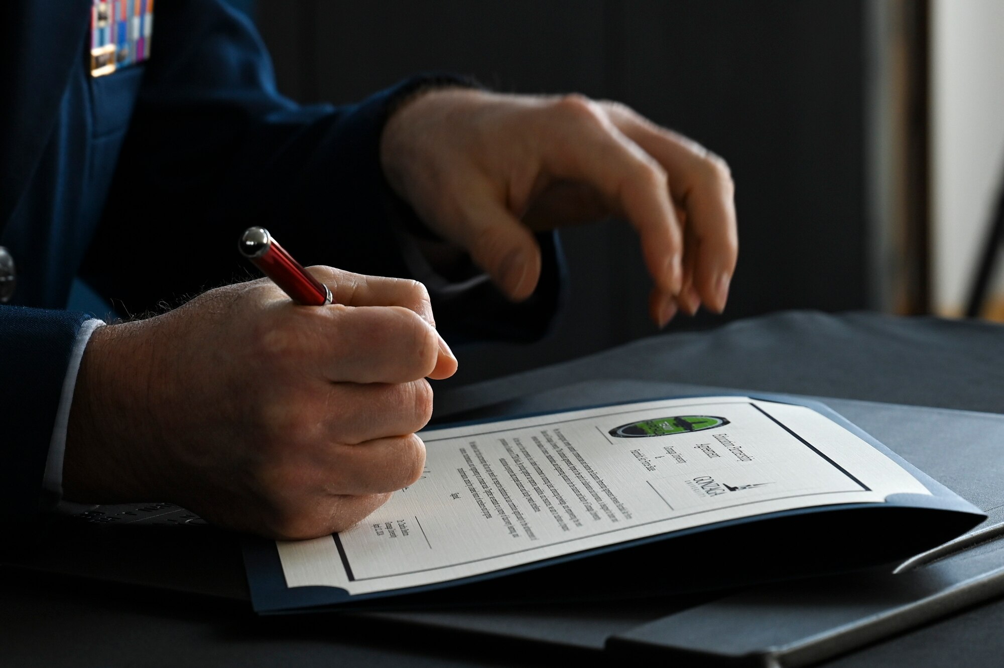 A close up shot of a man signing a document