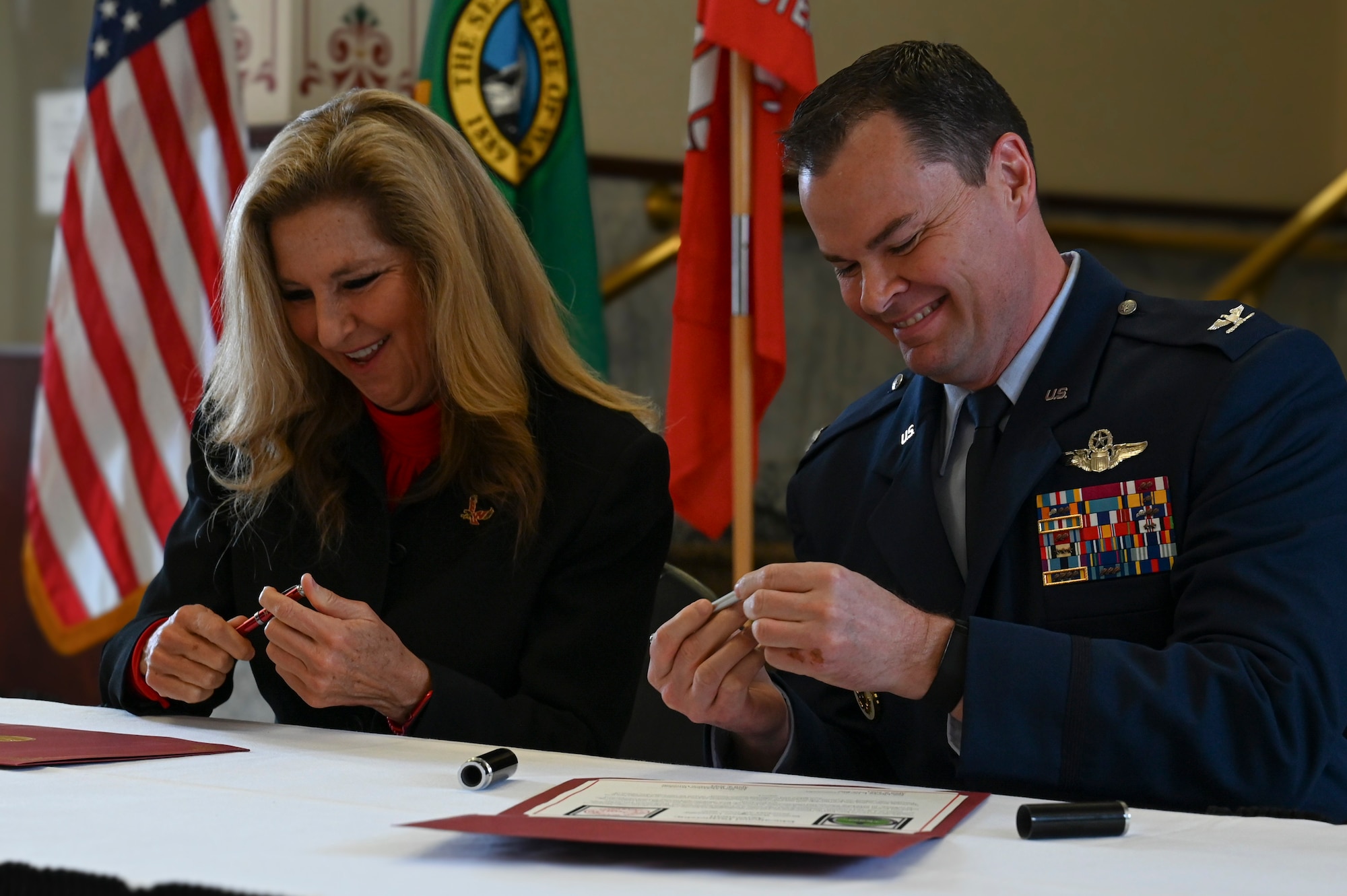 A man and a woman signing documents