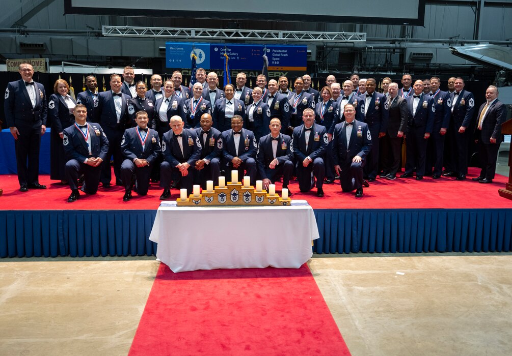 The chief master sergeants, active and retired, of Wright-Patterson Air Force Base, Ohio, gather on stage April 5, 2024, at the end of the chief recognition ceremony in the National Museum of the U.S. Air Force. The annual event honored 11 Wright-Patt Airmen selected for promotion to the Air Force’s highest enlisted rank. (U.S. Air Force photo by R.J. Oriez)