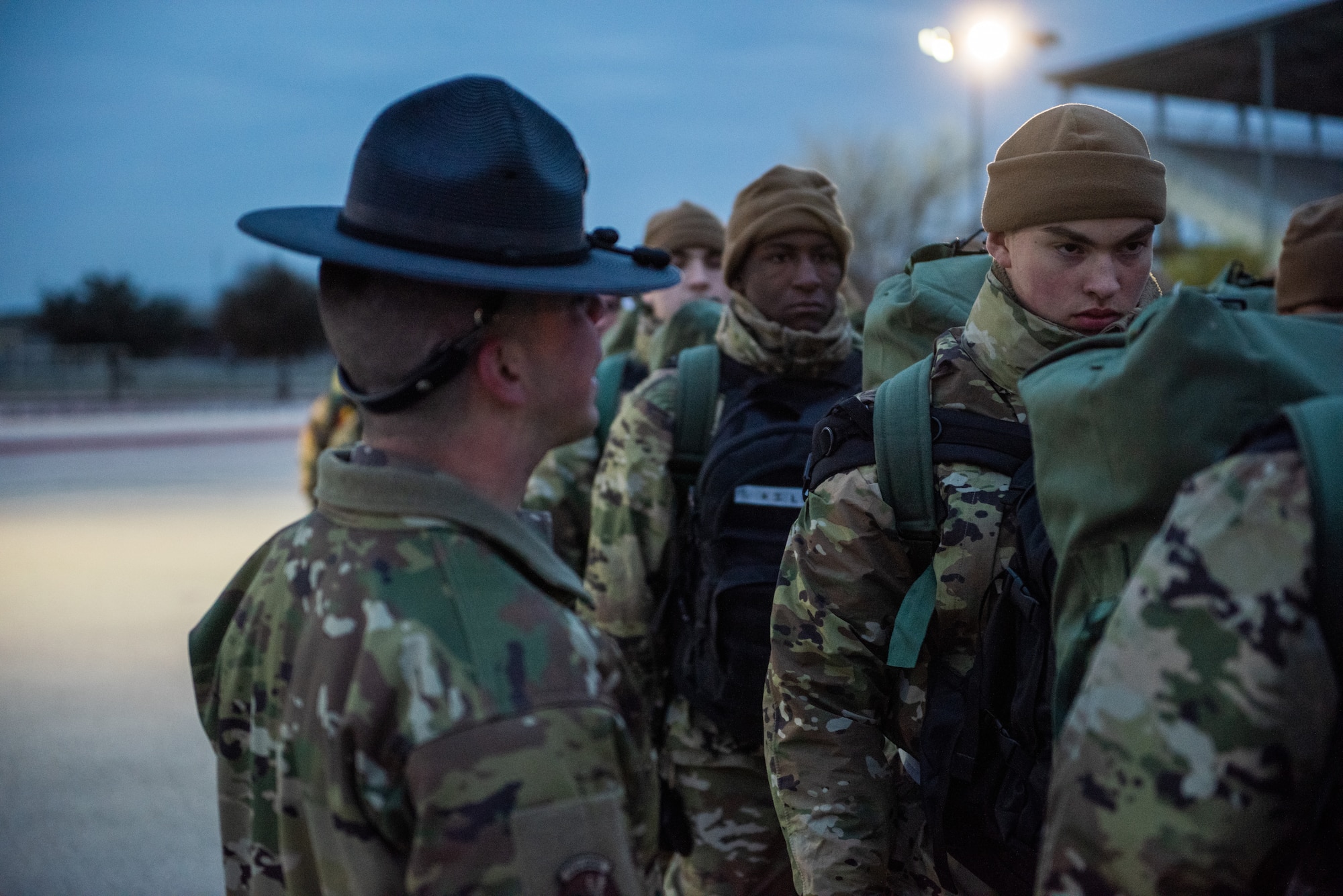 A Military Training Instructor addresses Basic Military Training trainees assigned to the 323rd Training Squadron on Jan. 20, 2024 at Joint Base San Antonio-Lackland, Texas, during culminating events on day five of Zero Week, known as Operation First Flight. Zero Week is the first five days of BMT where MTIs have the opportunity to optimize instruction before trainees are assigned to their BMT squadron. Zero Week serves as a deliberate process that not only assesses the initial competency and readiness of trainees but equips them with the essential tools needed to excel throughout their BMT journey.  (U.S. Air Force photo by Jonathan Cotto)
