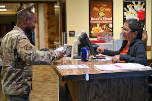 Vera Flores, 49th Force Support Squadron cashier, right, rings up a customer in the 49er Cafe at Holloman Air Force Base, New Mexico, March 27, 2024. The 49er Cafe recently unveiled a new menu featuring a selection of delectable breakfast and lunch items, along with coffee drinks for base personnel. (U.S. Air Force photo by Airman 1st Class Michelle Ferrari)