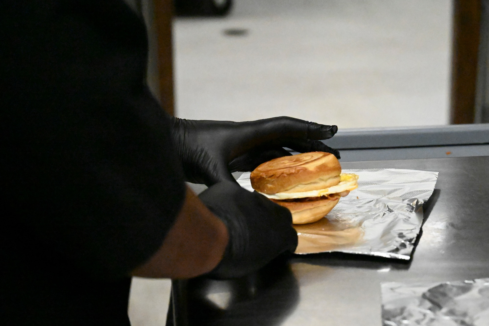 A 49th Force Support Squadron Airman from the 49er Cafe prepares a breakfast sandwich at Holloman Air Force Base, New Mexico, March 21, 2024. The 49er Cafe, located within Club Holloman, launched a new breakfast and lunch menu with a selection of salads, sandwiches, wraps, and grab-and-go items that provide everyone with easy and healthful options. (U.S. Air Force photo by Airman 1st Class Michelle Ferrari)