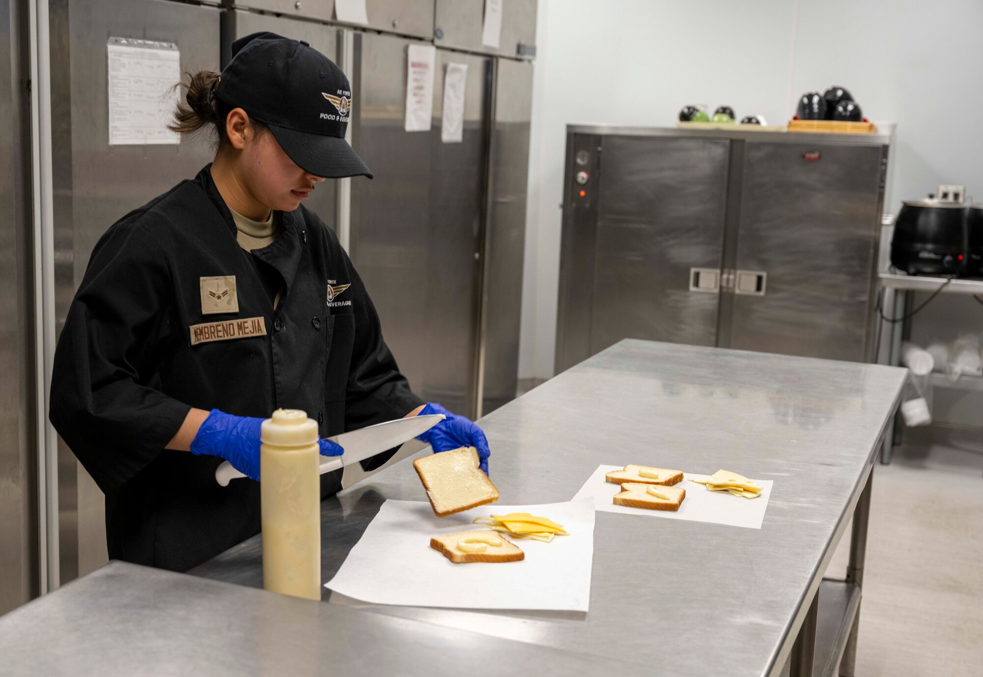 U.S. Air Force Airman 1st Class Nolvia Membreno Mejia, 49th Force Support Squadron food services apprentice, prepares a grilled cheese sandwich in the 49er Cafe at Holloman Air Force Base, New Mexico, March 27, 2024. The 49er Cafe, located within Club Holloman, launched a new breakfast and lunch menu with a selection of salads, sandwiches, wraps, and grab-and-go items that provide everyone with easy and healthful options. (U.S. Air Force photo by Airman 1st Class Michelle Ferrari)