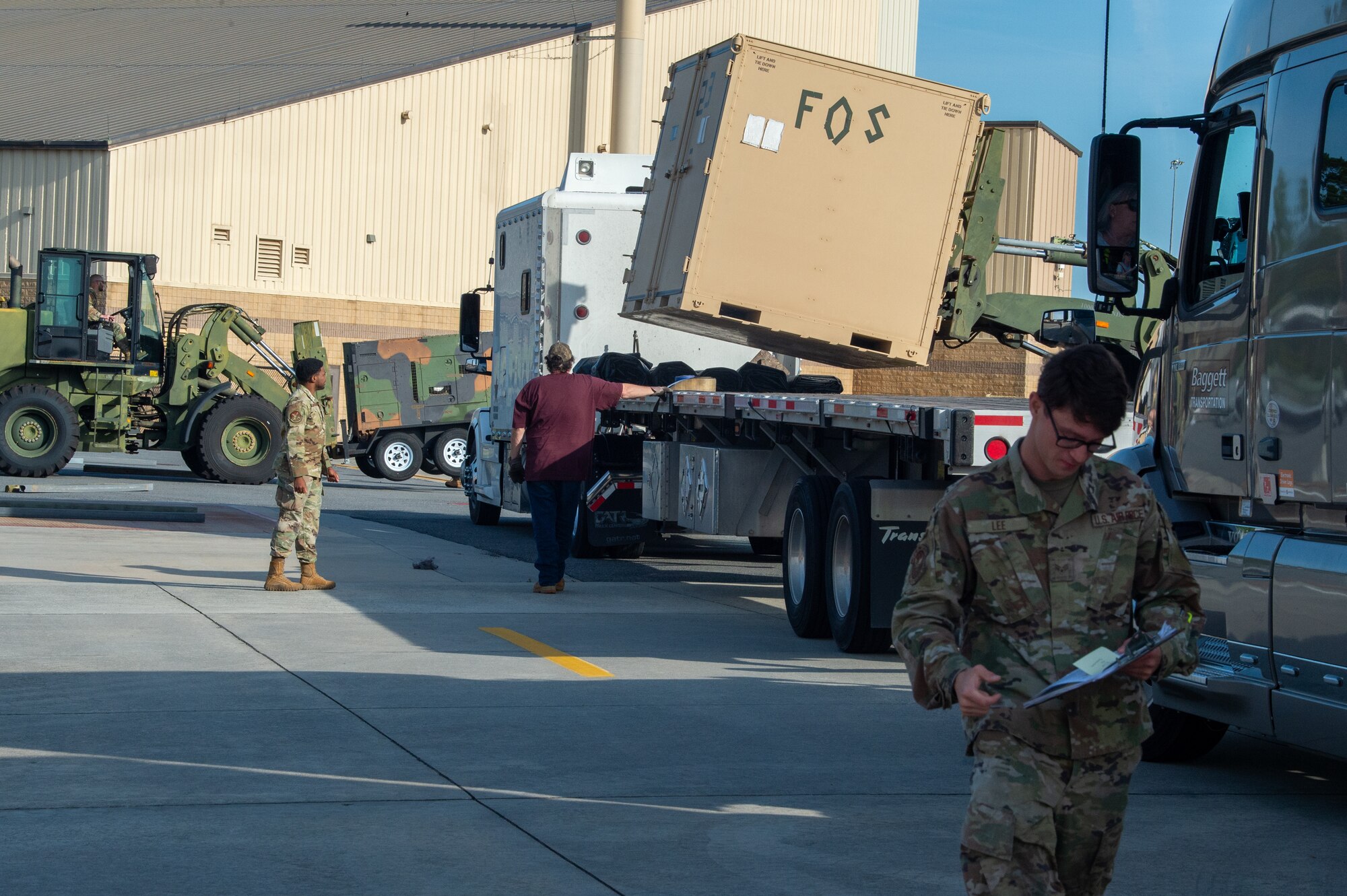 U.S. Air Force Senior Airman Lee, assigned to the 23rd Logistics Readiness Squadron, looks over documents while equipment is being loaded for Exercise Ready Tiger 24-1 at Moody Air Force Base, Georgia, April 8, 2024. The trucks were being used to assist in the transportation of supplies to various exercise locations.  The Ready Tiger 24-1 exercise evaluators will assess the 23rd Wing's proficiency in employing decentralized command and control to fulfill air tasking orders across geographically dispersed areas amid communication challenges. (U.S. Air Force photo by Airman 1st Class Iain Stanley)