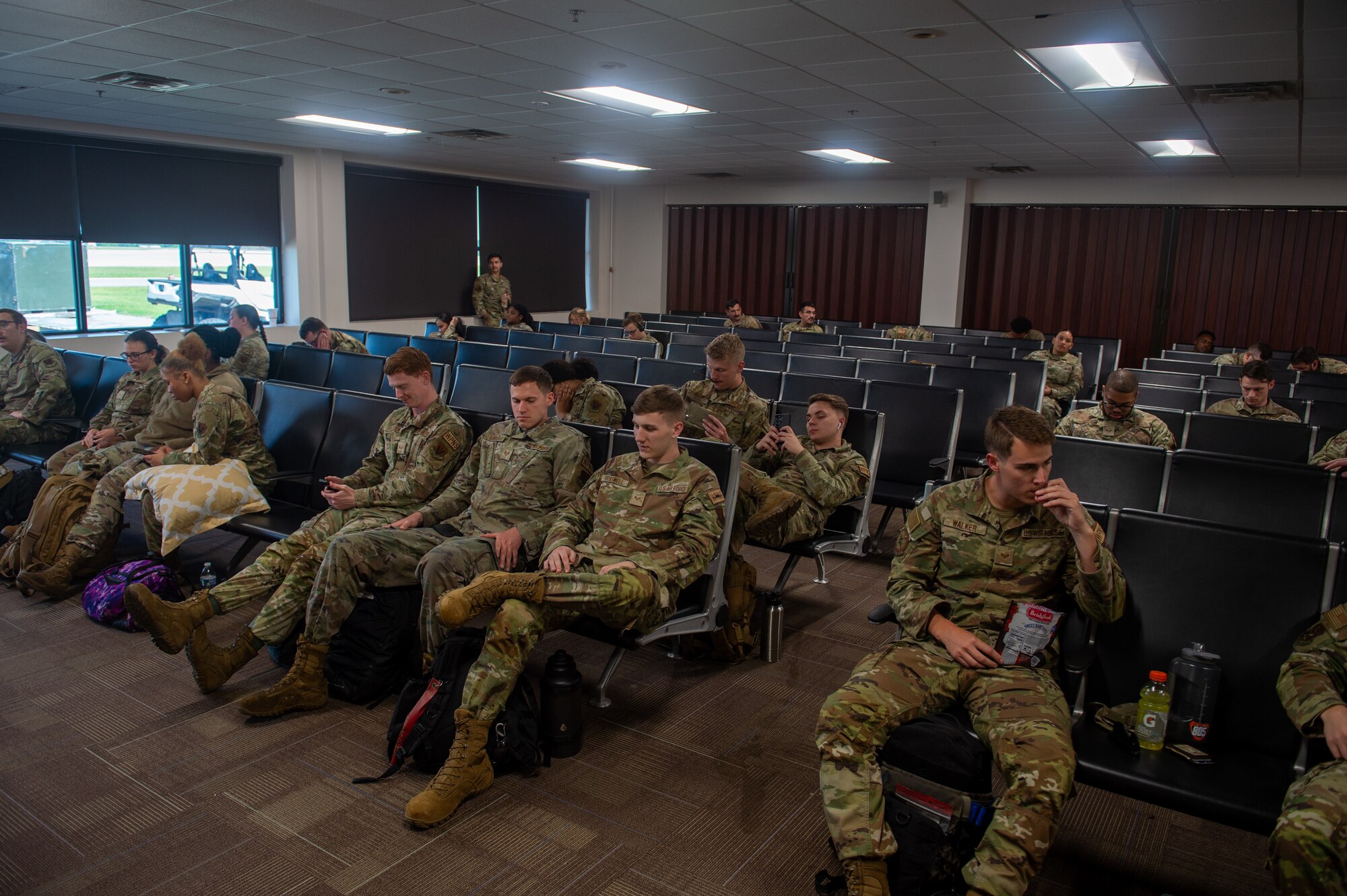 U.S. Air Force Airmen socialize in the Deployment Control Center’s waiting area in preparation for an upcoming flight during Exercise Ready Tiger 24-1 at Moody Air Force Base, Georgia, April 8, 2024. Built upon Air Combat Command's directive to assert air power in contested environments, Exercise Ready Tiger 24-1 aims to test and enhance the 23rd Wing’s proficiency in executing Lead Wing and Expeditionary Air Base concepts through Agile Combat Employment and command and control operations. (U.S. Air Force photo by Airman 1st Class Iain Stanley)