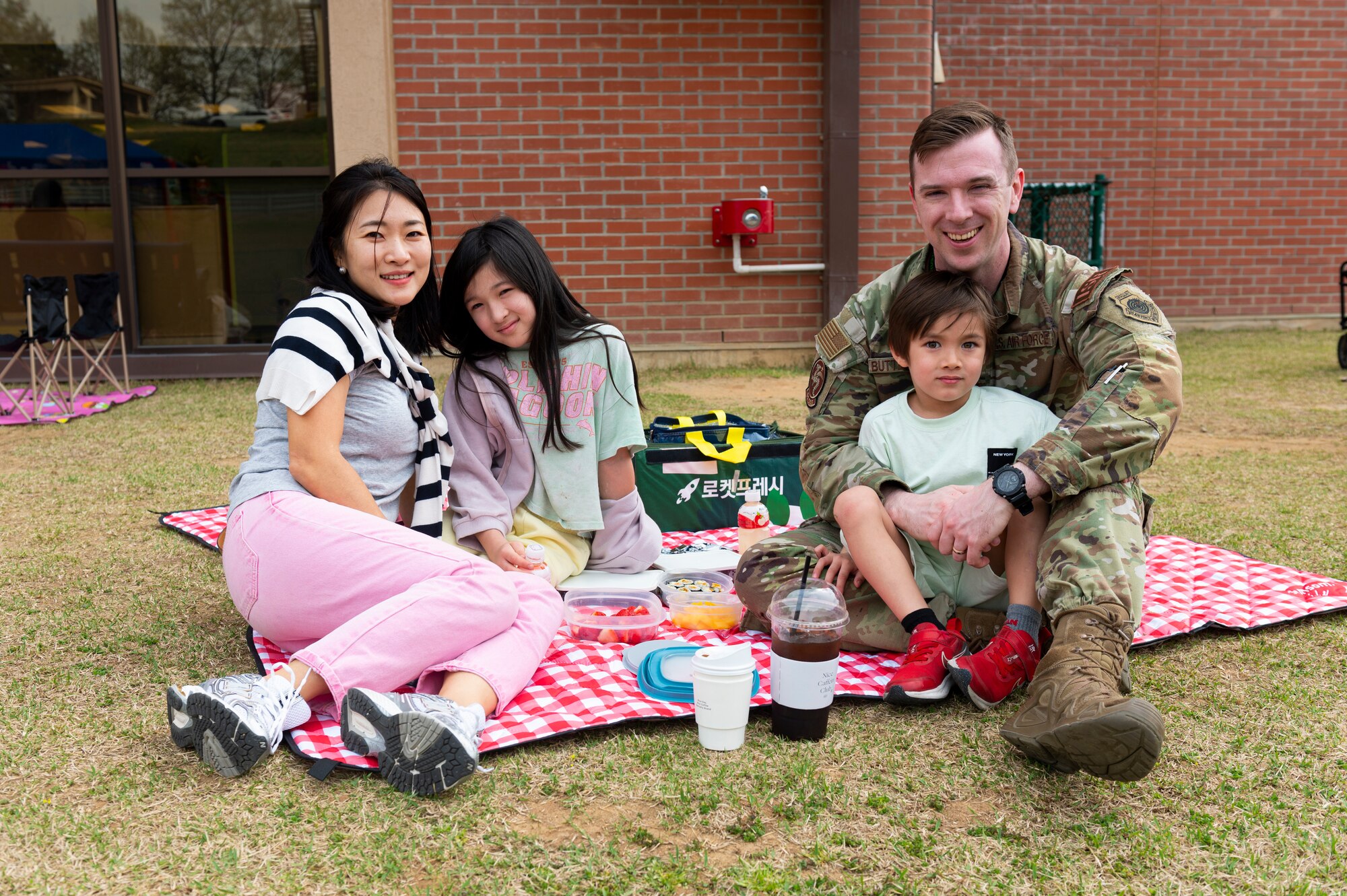 A U.S. Air Force Capt. Gregory Butterfield, 51st Operations Support Squadron intelligence weapons and tactics chief, poses for a photo with his family during a Month of the Military Child picnic at Osan Air Base, Republic of Korea, April 10, 2024. MotMC honors the unique experiences of children in military families. (U.S. Air Force photo by Senior Airman Kaitlin Frazier)