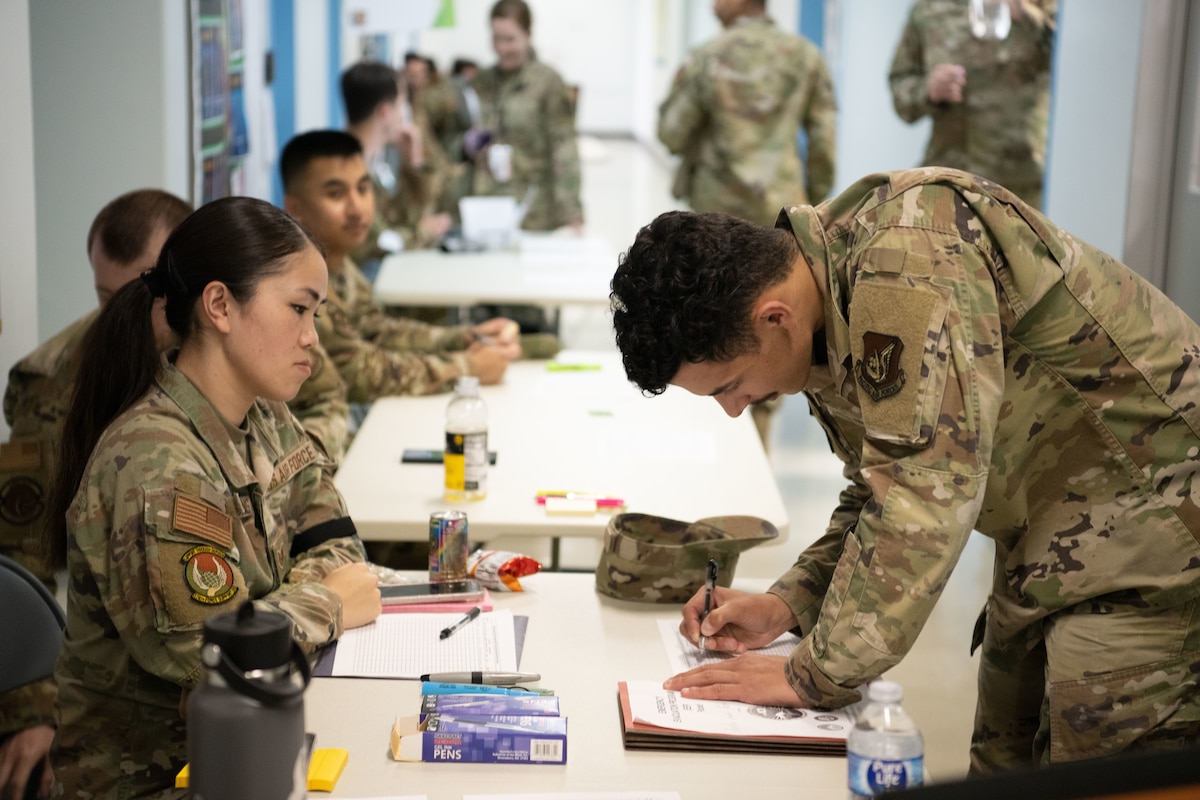 Photo of Airmen and community members in a simulated evacuation procedure processing line.