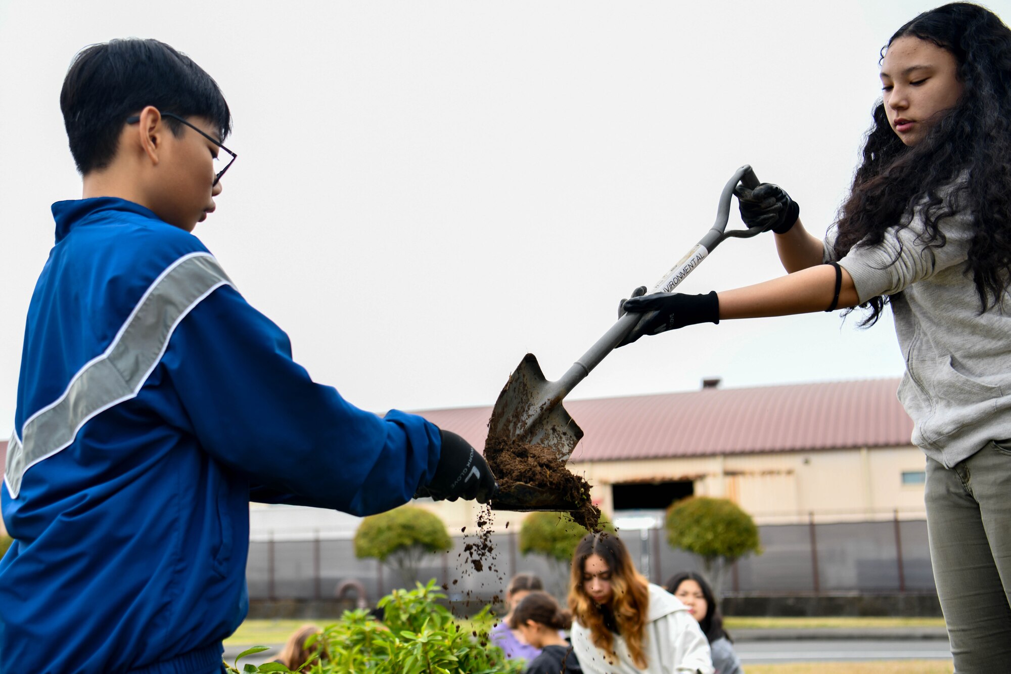 Students shovel dirt.