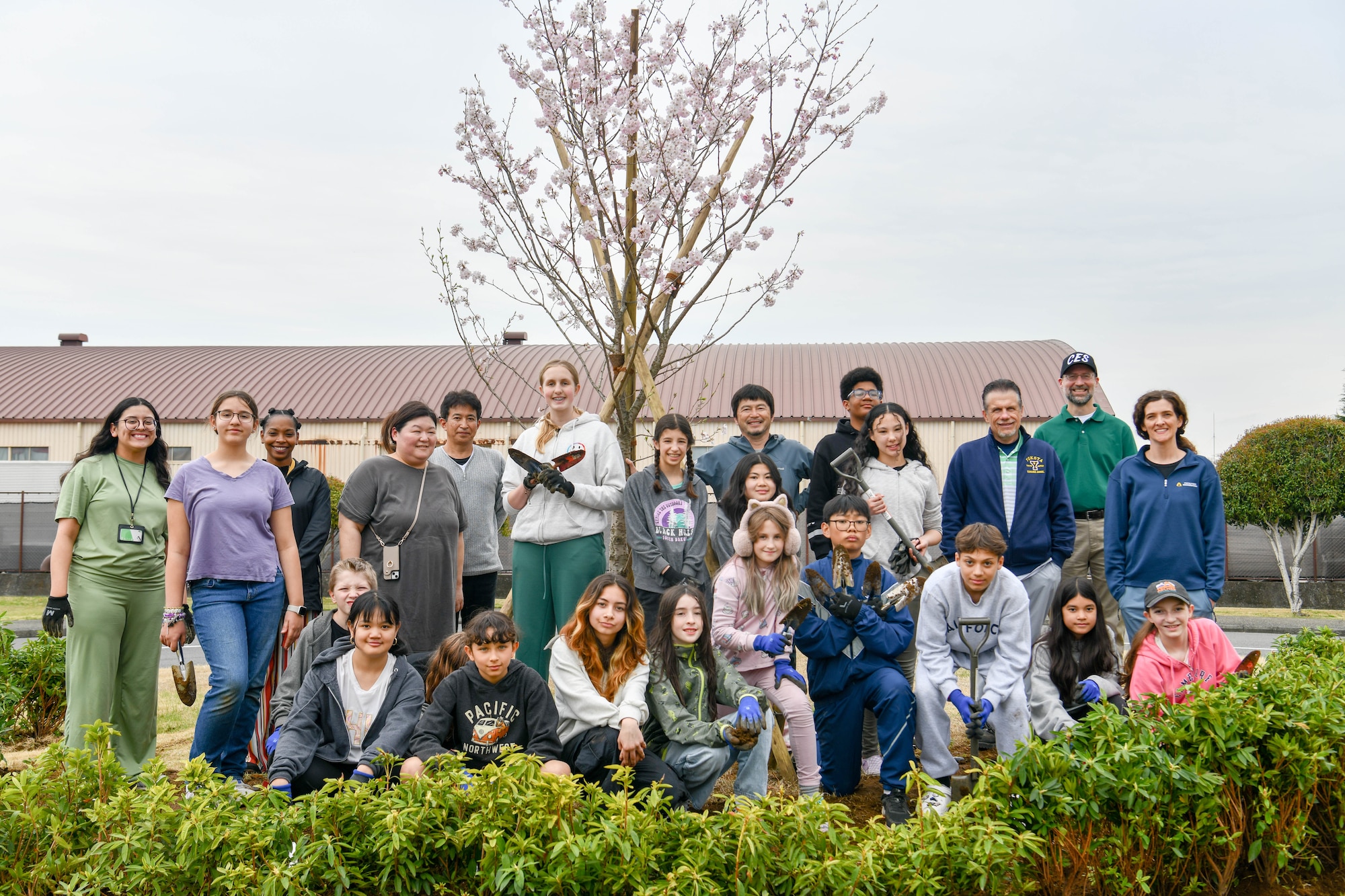 Students, school staff and members of the environmental section of the 374th Civil Engineer Squadron pose for a group photo.