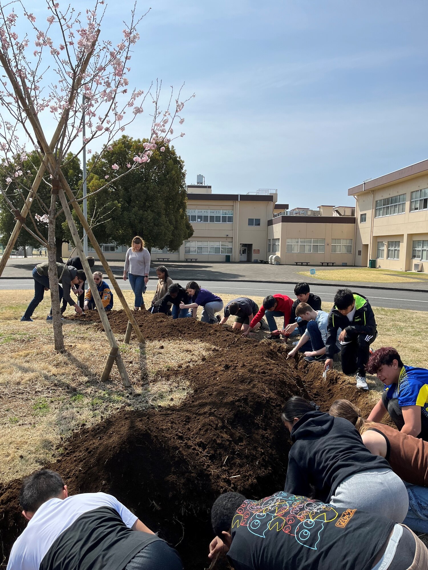 Junior Reserve Officers' Training Corps students from Yokota High School dig flower beds.