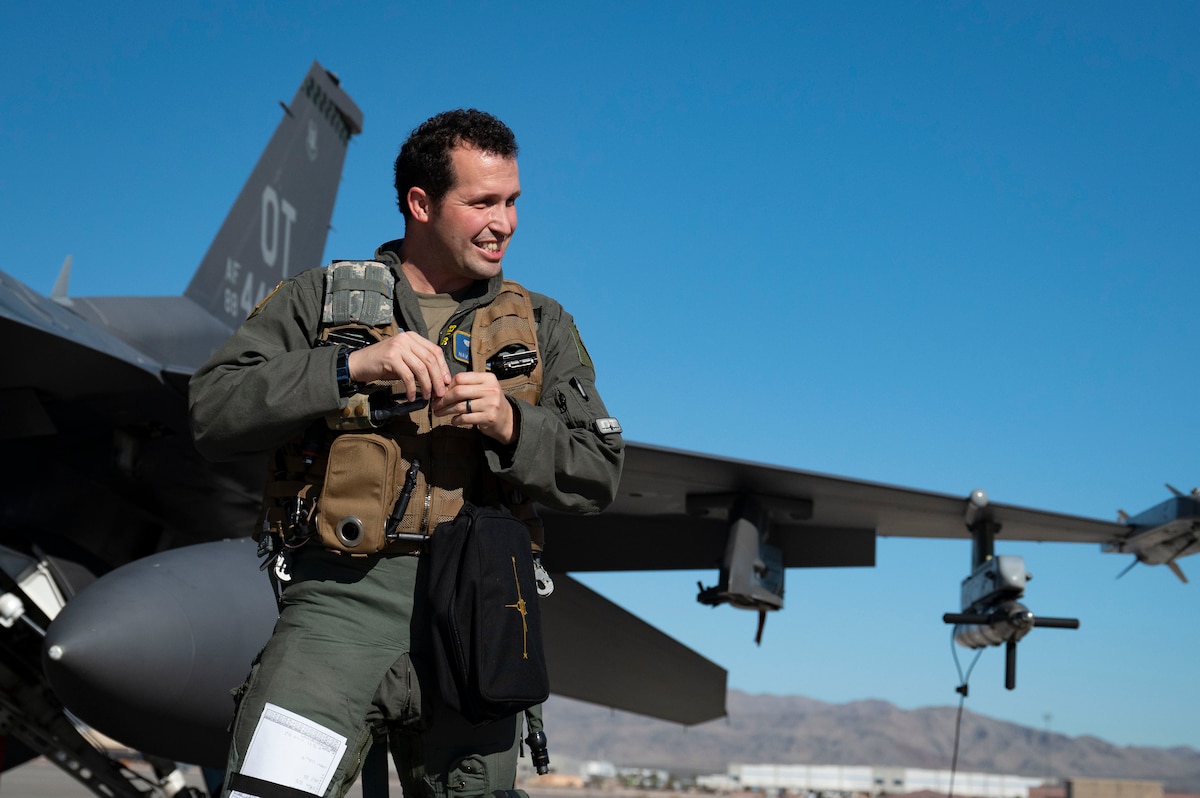 U.S. Air Force Lt. Col. Joshua Arnall, director of operations, 59th Test and Evaluation Squadron, adjusts the Integrated Cockpit Sensing, or ICS, system prior to flight tests on an F-16 at Nellis Air Force Base, Nevada, Jan. 30, 2024. An Air Force Research Laboratory team developed the ICS system to provide an airworthy platform for comprehensive physiological, life-support and environmental monitoring to improve pilot safety and performance. (U.S. Air Force photo / Senior Airman Megan Estrada)