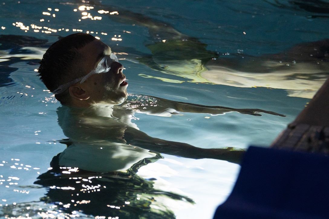 Close-up of a Marine coming up for air in a pool during training.