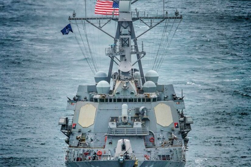 A Navy ship sails in open water.