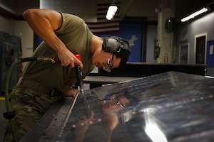 U.S. Air Force Airman Luis Carcamo-Blanco, 9th Maintenance Squadron aircraft structural maintenance apprentice, uses a rivet tool on a simulated aircraft structure on Beale Air Force Base, California, Dec. 19, 2023.