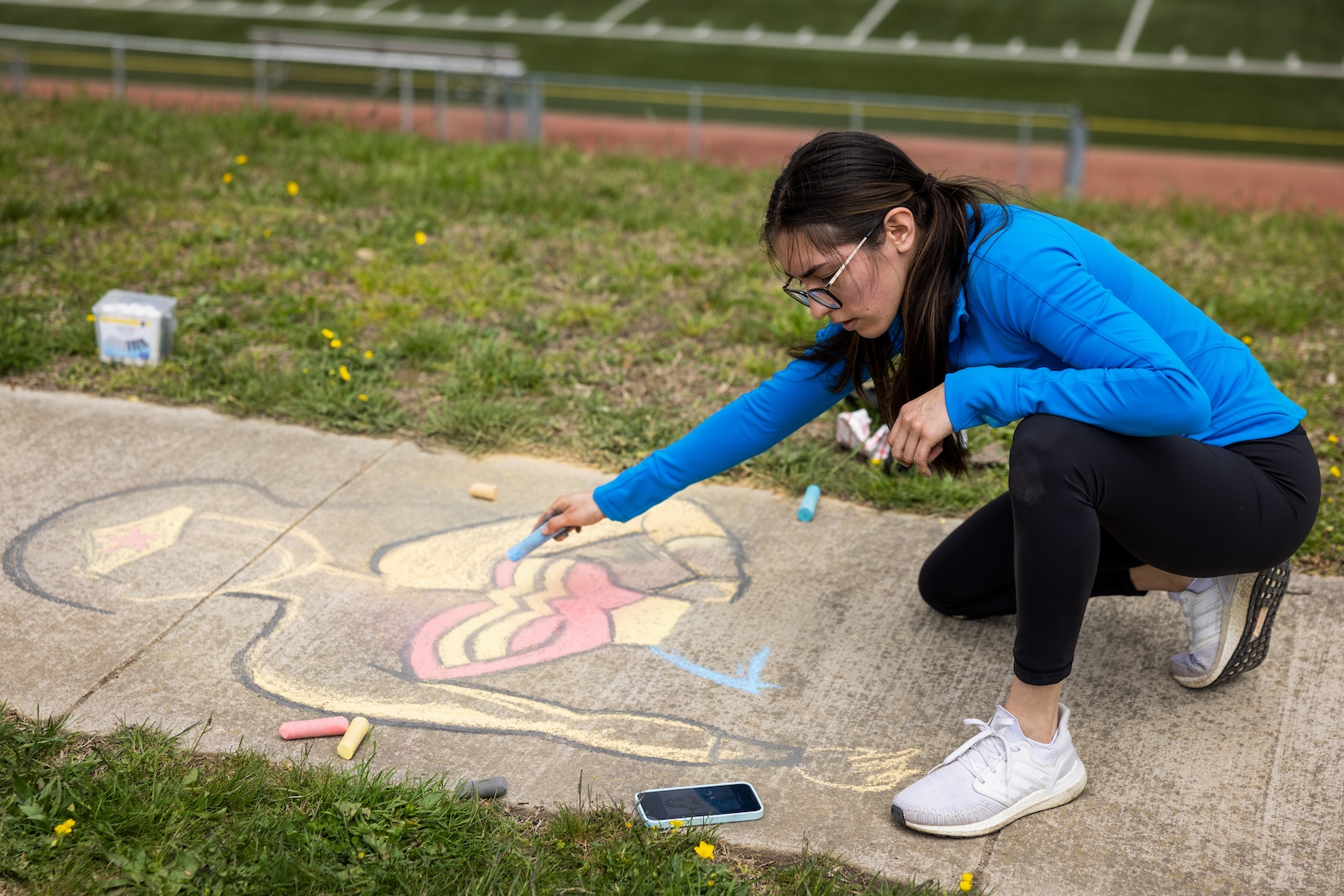 U.S. Marine Corps Sgt. Emily Sevillano Meza, a data systems administrator with Marine Corps Cyberspace Operations Group, an Arizona native, participates in a Chalk the Walk session during the Spin Against Sexual Assault event at Butler Stadium on Marine Corps Base Quantico, Virginia, April 12, 2024. This event provides an opportunity for MCBQ military and civilian personnel to collaborate in different group activities such as spin classes, group art, chalk the walk, and training from the Office of the Special Trial Counsel. (U.S. Marine Corps photo by Lance Cpl. Ethan Miller)