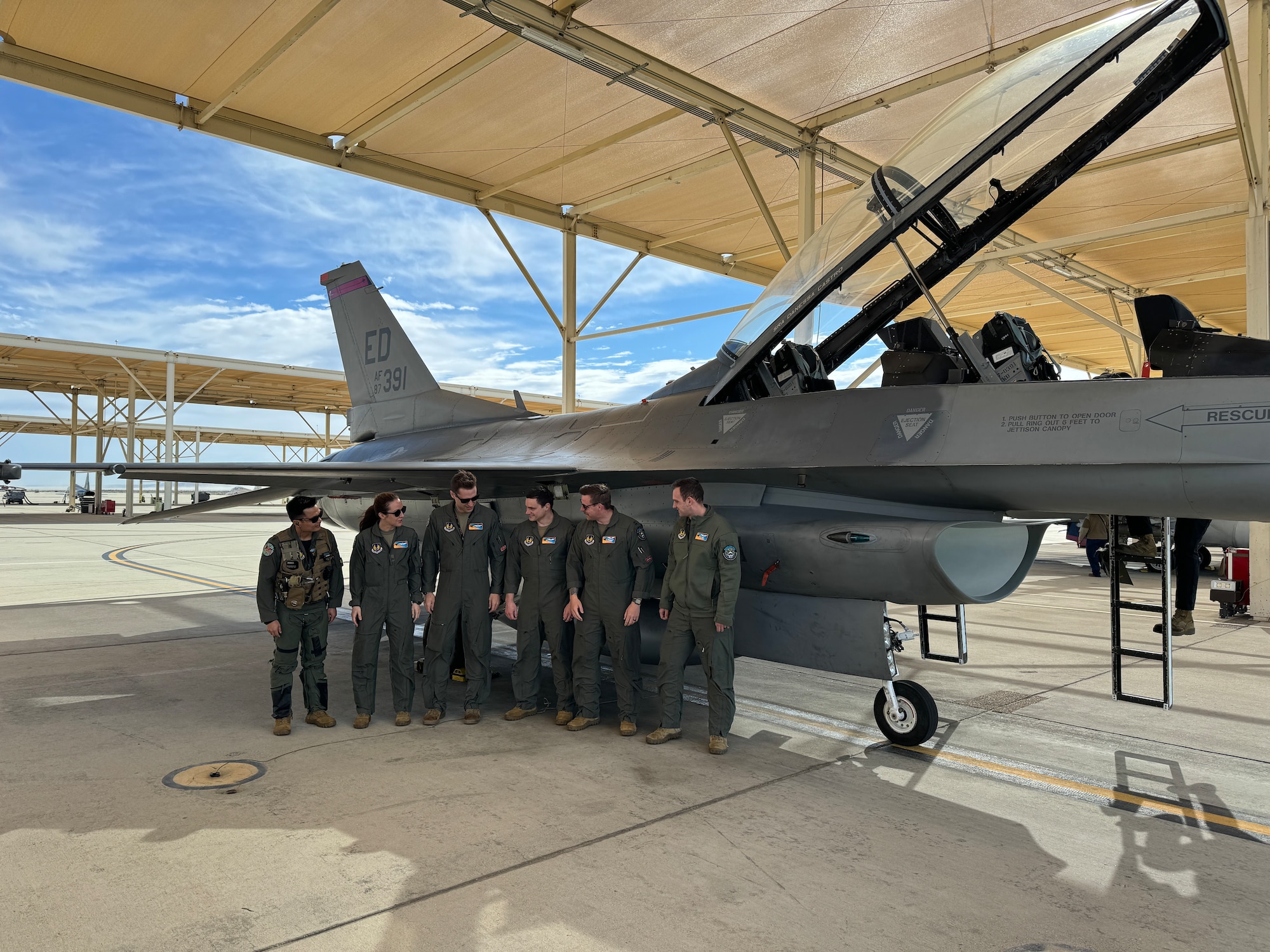 U.S. Air Force Test Pilot School students prepare to flight test the Integrated Cockpit Sensing, or ICS, system on an F-16 at Edwards Air Force Base, California, March 12, 2024. An Air Force Research Laboratory team developed the ICS system to provide an airworthy platform for comprehensive physiological, life-support and environmental monitoring to improve pilot safety and performance. The system has helmet-based, base layer and life- support sensors, ensuring holistic information on the pilot and operating environment during flight. (U.S. Air Force photo / Wei Lee)
