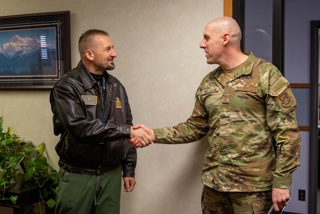 Italian Air Force Col. Vito Cracas, RED FLAG-Alaska Italian Detachment commander, shakes hands with U.S. Air Force Chief Master Sgt. Sean Milligan, 354th Fighter Wing command chief.
