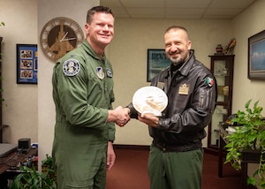 U.S. Air Force Col. Paul Townsend, 354th Fighter Wing commander, shakes hands with Italian Air Force Col. Vito Cracas, RED FLAG-Alaska Italian Detachment commander and exchange a wooden plaque gift.