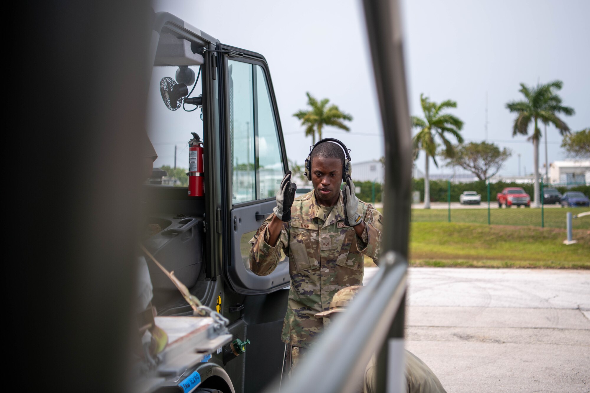 An Airman in uniform directs a driver to position a vehicle on the flight line at Naval Station Key West, Florida.