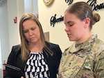 Jennifer Smith, Special Victim Liaison program director, discusses dates for upcoming court-martials with Master Sgt. Margaret Murphy at the Army Office of Special Trial Counsel headquarters, Fort Belvoir, Virginia, March 14, 2024. (U.S. Army photo by Michelle McCaskill)