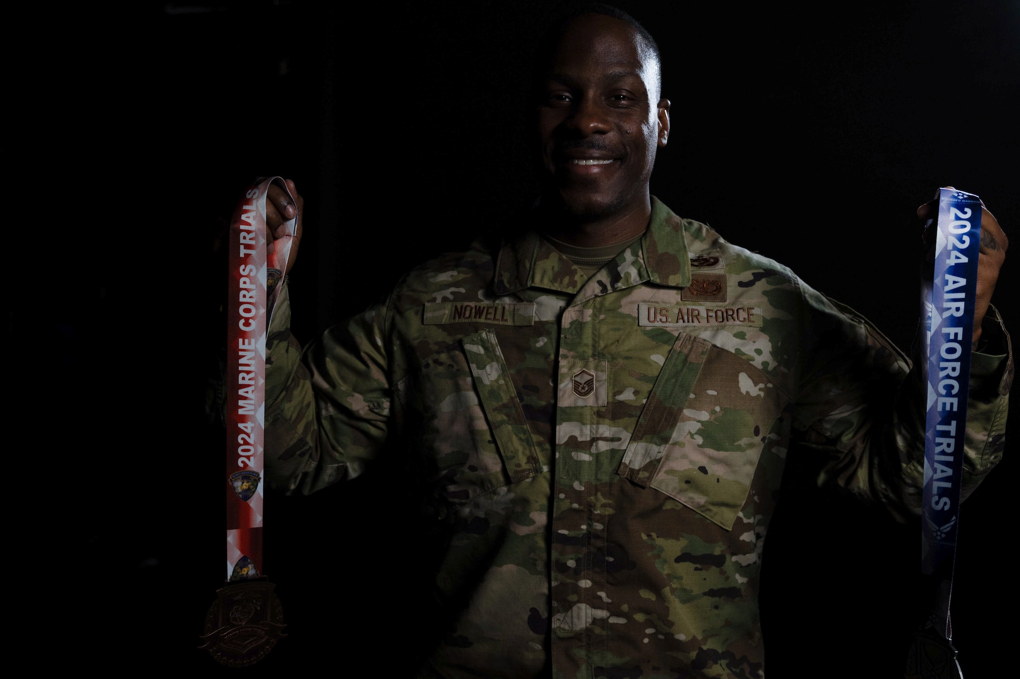 U.S. Air Force Master Sgt. Corey Nowell, 436th Aerial Port Squadron traffic management flight superintendent, poses for a photo with the medals he won at the 2024 Air Force and Marine Corps Trials on Dover Air Force Base, Delaware, April 11, 2024. Nowell is preparing for an annual multi-adaptive sports competition known as the Department of Defense Warrior Games. (U.S. Air Force photo by Airman 1st Class Dieondiere Jefferies)