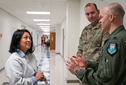 A photo of three people talking.