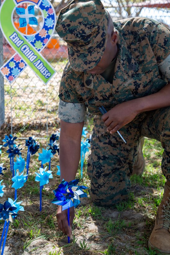 Sergeant Major Miller Daceus, base sergeant major at Marine Corps Logistics Base Barstow, puts a pinwheel in the ground as part of Pinwheels for Prevention at the Child Development Center on base, April 3, 2024. April is National Child Abuse Prevention Month, dedicated to raising awareness for this crime.