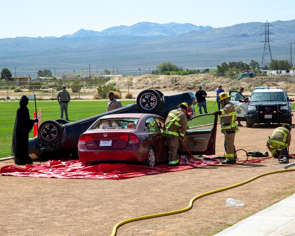 Firefighters from Marine Corps Logistics Base Barstow fire department use the Jaws of Life in response to a simulated 911 call for a drunk-driving crash at Silver Valley High School in Yermo, California, April 4, 2024. The drunk driving scenario was reenacted as part of California Highway Patrol's Every 15 Minutes campaign, a program targeted to make high school students consider the consequences of drinking and driving.