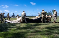 U.S. Air Force Airmen from the 3rd Air Expeditionary Wing out of Joint Base Elmendorf-Richardson, Alaska, stage an expeditionary tent for base buildup during Exercise Agile Reaper 24-1 at Tinian Forward Operating Site, Northern Mariana Islands, April 8, 2024. The expeditious build-up of the Tinian FOS was made possible through the employment of the Air Force concept of Mission-Ready Airmen. MRA optimizes wartime operational mission generation through Airmen working side-by-side with Airmen outside their Air Force Specialty Code and applying those core skills when needed, in order to make the mission happen. In a wartime environment, ensuring redundancies with Airmen understanding and being able to act outside their core specialty will increase the survivability and effectiveness of forces in the Pacific. (U.S. Air Force photo by Tech. Sgt. Curt Beach)