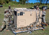 U.S. Air Force Airmen from the 3rd Air Expeditionary Wing out of Joint Base Elmendorf-Richardson, Alaska, offload a power distribution panel during Exercise Agile Reaper 24-1 at Tinian Forward Operating Site, Northern Mariana Islands, April 8, 2024. The expeditious build-up of the Tinian FOS was made possible through the employment of the Air Force concept of Mission-Ready Airmen. MRA optimizes wartime operational mission generation through Airmen working side-by-side with Airmen outside their Air Force Specialty Code and applying those core skills when needed, in order to make the mission happen. In a wartime environment, ensuring redundancies with Airmen understanding and being able to act outside their core specialty will increase the survivability and effectiveness of forces in the Pacific. (U.S. Air Force photo by Tech. Sgt. Curt Beach)