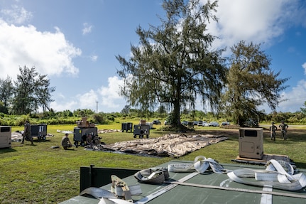 Expeditionary tents, power distribution panels and HVAC units are staged for base buildup during Exercise Agile Reaper 24-1 at Tinian Forward Operating Site, Northern Mariana Islands, April 9, 2024. Tinian FOS is an austere environment next to Tinian International Airport, and while it began as a barren patch of grass, in less than 24 hours, a few dozen Airmen stood up and began operating it as a fully mission-capable forward operating site comprised of approximately 100 Airmen with all the necessary military support functions to service and launch military aircraft, namely JBER’s F-22 Raptors from the 90th Fighter Squadron. (U.S. Air Force photo by Tech. Sgt. Curt Beach)