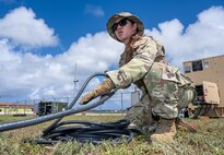 U.S. Air Force Tech. Sgt. Mazoccorro Lamigo, NCOIC of generator operations assigned to 773d Expeditionary Civil Engineer Squadron out of Joint Base Elmendorf-Richardson, Alaska, sets up power cables to supply power to the camp during Exercise Agile Reaper 24-1 at Tinian Forward Operating Site, Northern Mariana Islands, April 9, 2024. The expeditious build-up of the Tinian FOS was made possible through the employment of the Air Force concept of Mission-Ready Airmen. MRA optimizes wartime operational mission generation through Airmen working side-by-side with Airmen outside their Air Force Specialty Code and applying those core skills when needed, in order to make the mission happen. In a wartime environment, ensuring redundancies with Airmen understanding and being able to act outside their core specialty will increase the survivability and effectiveness of forces in the Pacific. (U.S. Air Force photo by Tech. Sgt. Curt Beach)