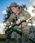 U.S. Air Force Staff Sgt. Cole Durand, a 3rd Expeditionary Operations Support Squadron Survival, Evasion, Resistance and Escape specialist out of Joint Base Elmendorf-Richardson, Alaska, splits bamboo in order to build a shelter during Exercise Agile Reaper 24-1 at Tinian Forward Operating Site, Northern Mariana Islands, April 9, 2024. Tinian FOS is an austere environment next to Tinian International Airport, and while it began as a barren patch of grass, in less than 24 hours, a few dozen Airmen stood up and began operating it as a fully mission-capable forward operating site comprised of approximately 100 Airmen with all the necessary military support functions to service and launch military aircraft, namely JBER’s F-22 Raptors from the 90th Fighter Squadron. (U.S. Air Force photo by Tech. Sgt. Curt Beach)