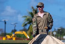 A U.S. Air Force Airman assigned to the 3rd Air Expeditionary Wing out of Joint Base Elmendorf-Richardson, Alaska, assembles an expeditionary tent during Exercise Agile Reaper 24-1 at Tinian Forward Operating Site, Northern Mariana Islands, April 9, 2024. The expeditious build-up of the Tinian FOS was made possible through the employment of the Air Force concept of Mission-Ready Airmen. MRA optimizes wartime operational mission generation through Airmen working side-by-side with Airmen outside their Air Force Specialty Code and applying those core skills when needed, in order to make the mission happen. In a wartime environment, ensuring redundancies with Airmen understanding and being able to act outside their core specialty will increase the survivability and effectiveness of forces in the Pacific. (U.S. Air Force photo by Tech. Sgt. Curt Beach)