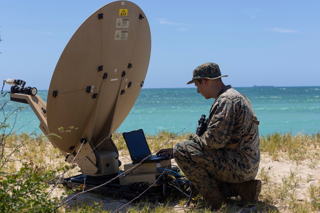 U.S. Marine Corps Lance Cpl. Austin Jinapuck, a defensive cyberspace warfare operator with 3rd Radio Battalion, III Marine Expeditionary Force Information Group, establishes communications using a Mercury Dawn communication dish during a signals intelligence collection operation at Joint Base Pearl Harbor-Hickam, Hawaii on April 10, 2024. Cyberspace Marines analyzed signal intelligence reports and relayed collected intelligence back to the combat operation center as part of exercise Corvus Dawn 24 battalion operations. CD24 sharpened 3rd RADBN's ability to provide technical information related capabilities to III MEF and the joint and multi-national force throughout the Indo-Pacific region. Jinapuck is a native of Oregon.  (U.S. Marine Corps photo by Cpl. Bridgette Rodriguez)