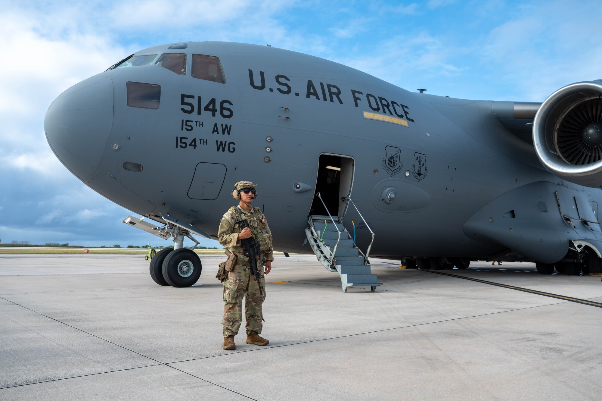 Airman stands in front of an aircraft.