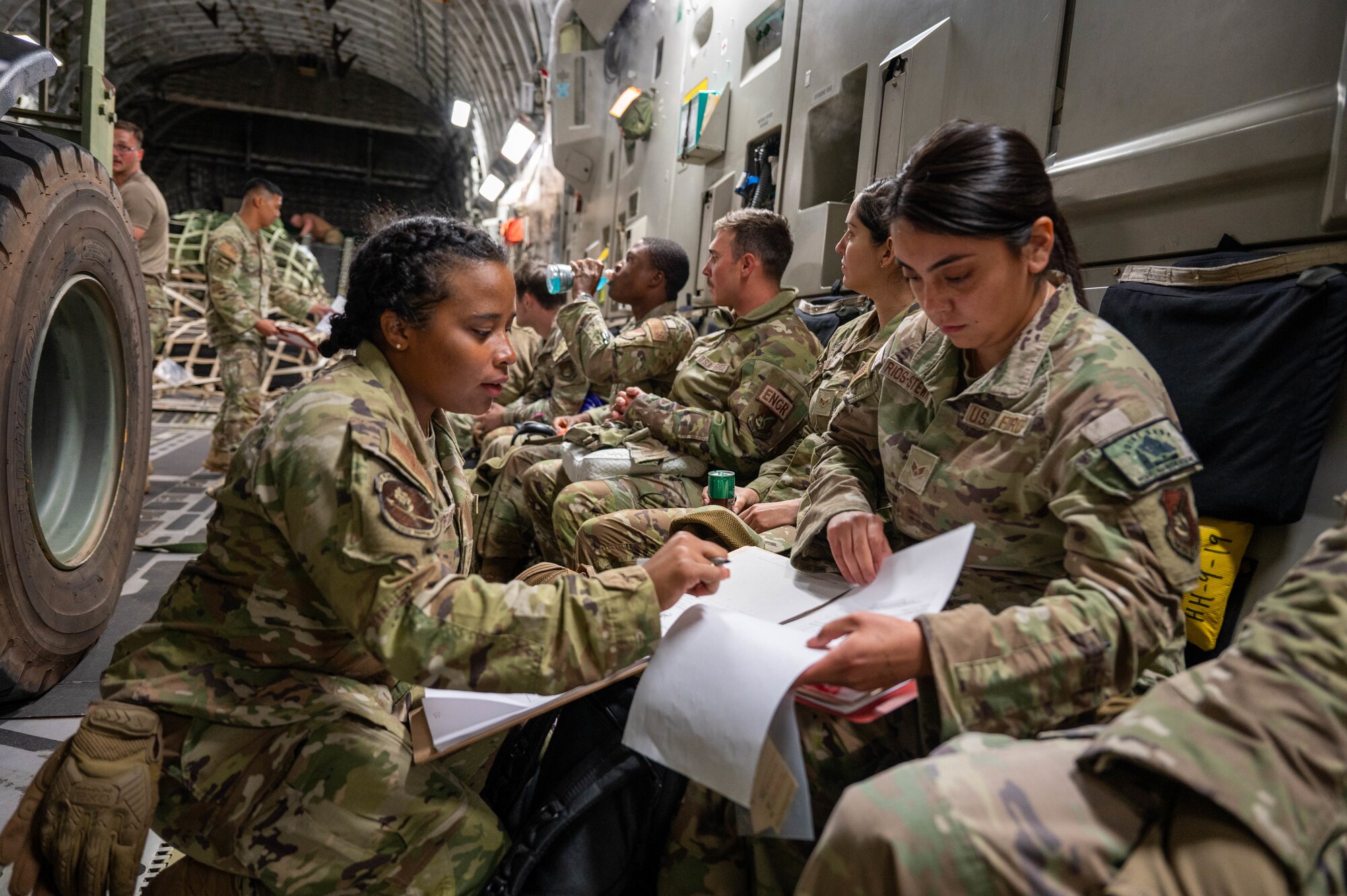 Airmen complete paperwork inside of an aircraft.