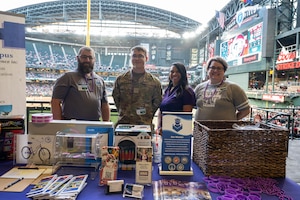 Volunteers from the 56th Fighter Wing and Wayland Baptist University present a booth during a  Purple Up Arizona Diamondbacks game, April 12, 2024, in Phoenix, Arizona.