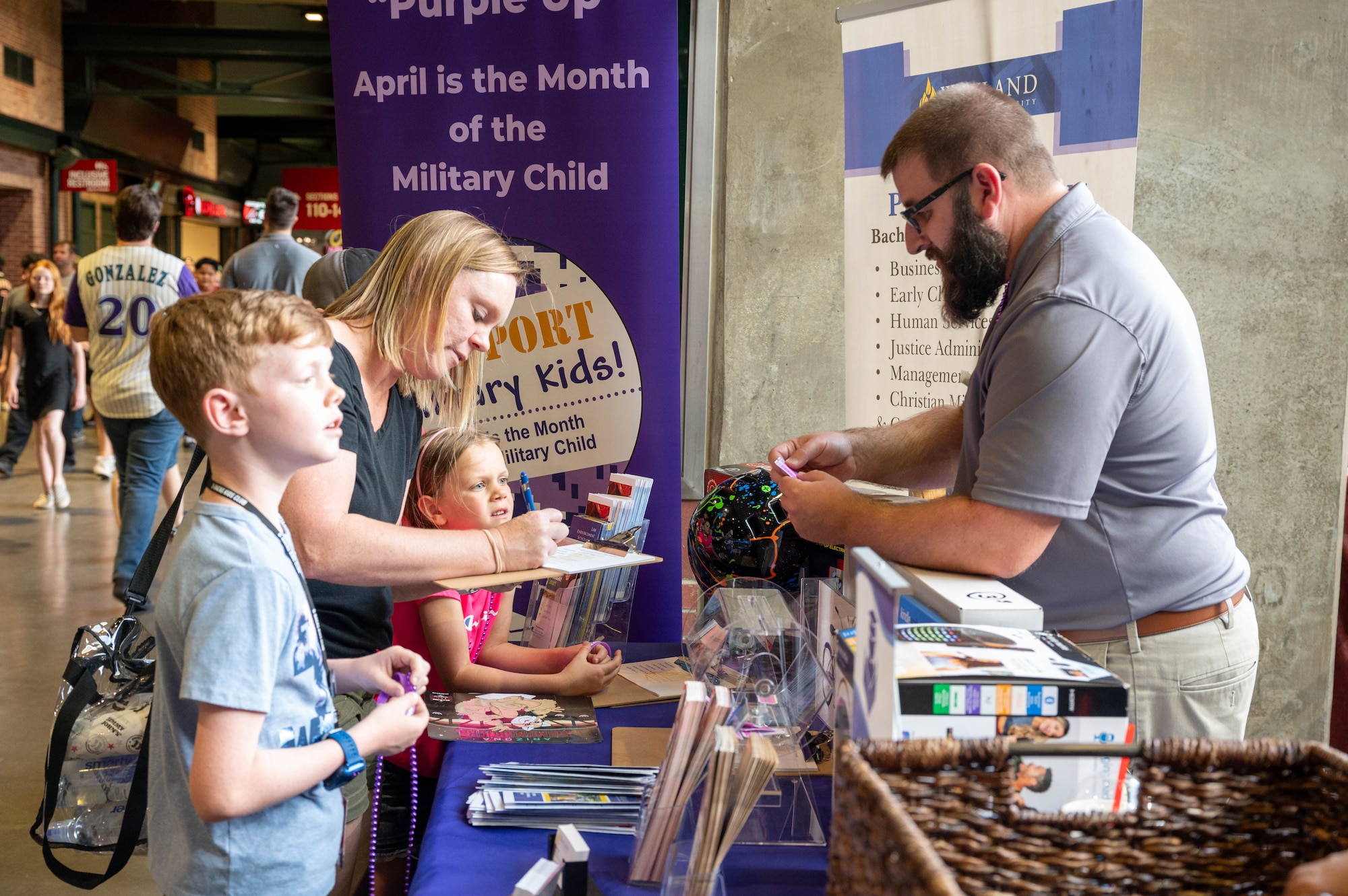 Lance Dare, Wayland Baptist University site coordinator, interacts with a local family during a Purple Up Arizona Diamondbacks game, April 12, 2024, in Phoenix, Arizona.
