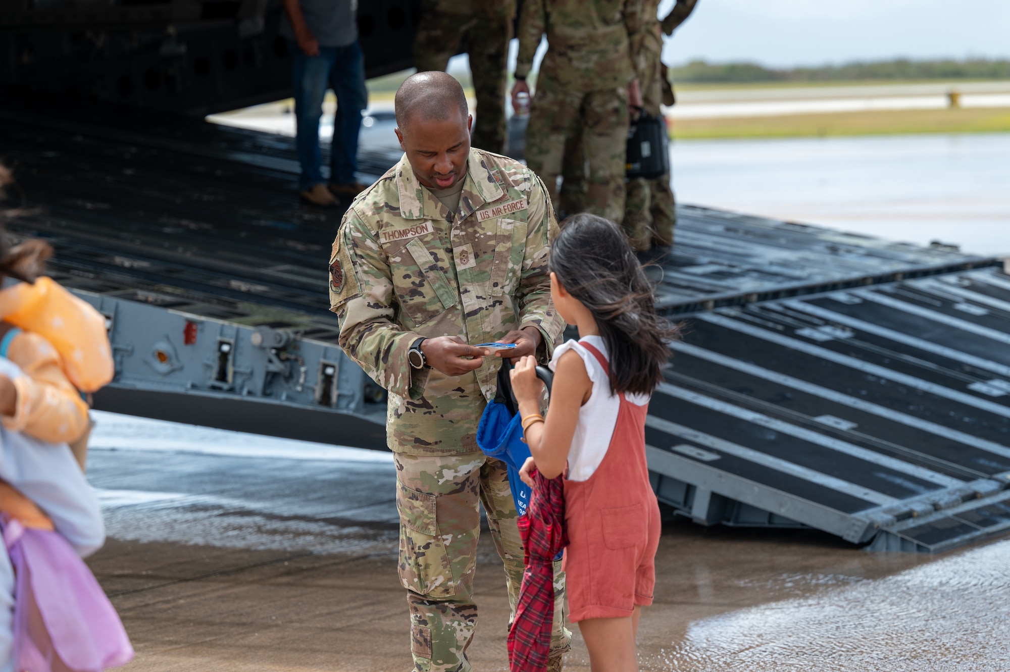 Chief Master Sgt. Anthony Thompson Jr., 15th Wing command chief, hands out Air Force swag during a community day at Saipan, Northern Marianas Islands, April 13, 2024. During the event participants explored three military aircraft and had the opportunity to talk to Airmen about their jobs and the capabilities of the aircraft. (U.S. Air Force photo by Senior Airman Mark Sulaica)