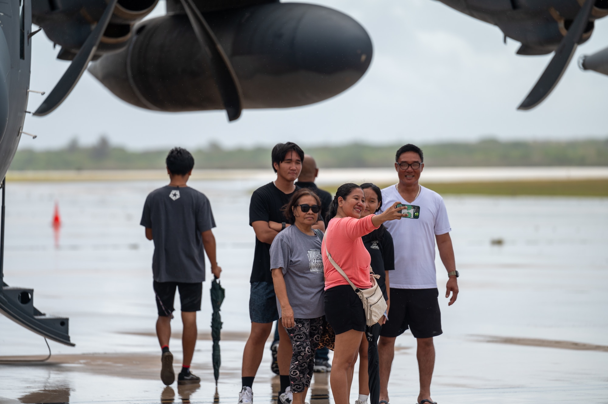 A family takes a group photo during a community day hosted by the 15th Wing and 3rd Air Expeditionary Wing at Saipan, Northern Marianas, April 13, 2024. During the event participants explored three military aircraft and had the opportunity to talk to Airmen about their jobs and the capabilities of the aircraft. (U.S. Air Force photo by Senior Airman Mark Sulaica)