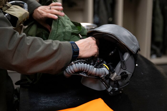 An Integrated Cockpit Sensing, or ICS, system with helmet-based, base layer and life-support sensors is examined prior to flight testing with the 422d Test and Evaluation Squadron at Nellis Air Force Base, Nevada, Jan. 30, 2024. An Air Force Research Laboratory team developed the ICS system to provide an airworthy platform for comprehensive physiological, life-support and environmental monitoring to improve pilot safety and performance. (U.S. Air Force photo / Senior Airman Megan Estrada)