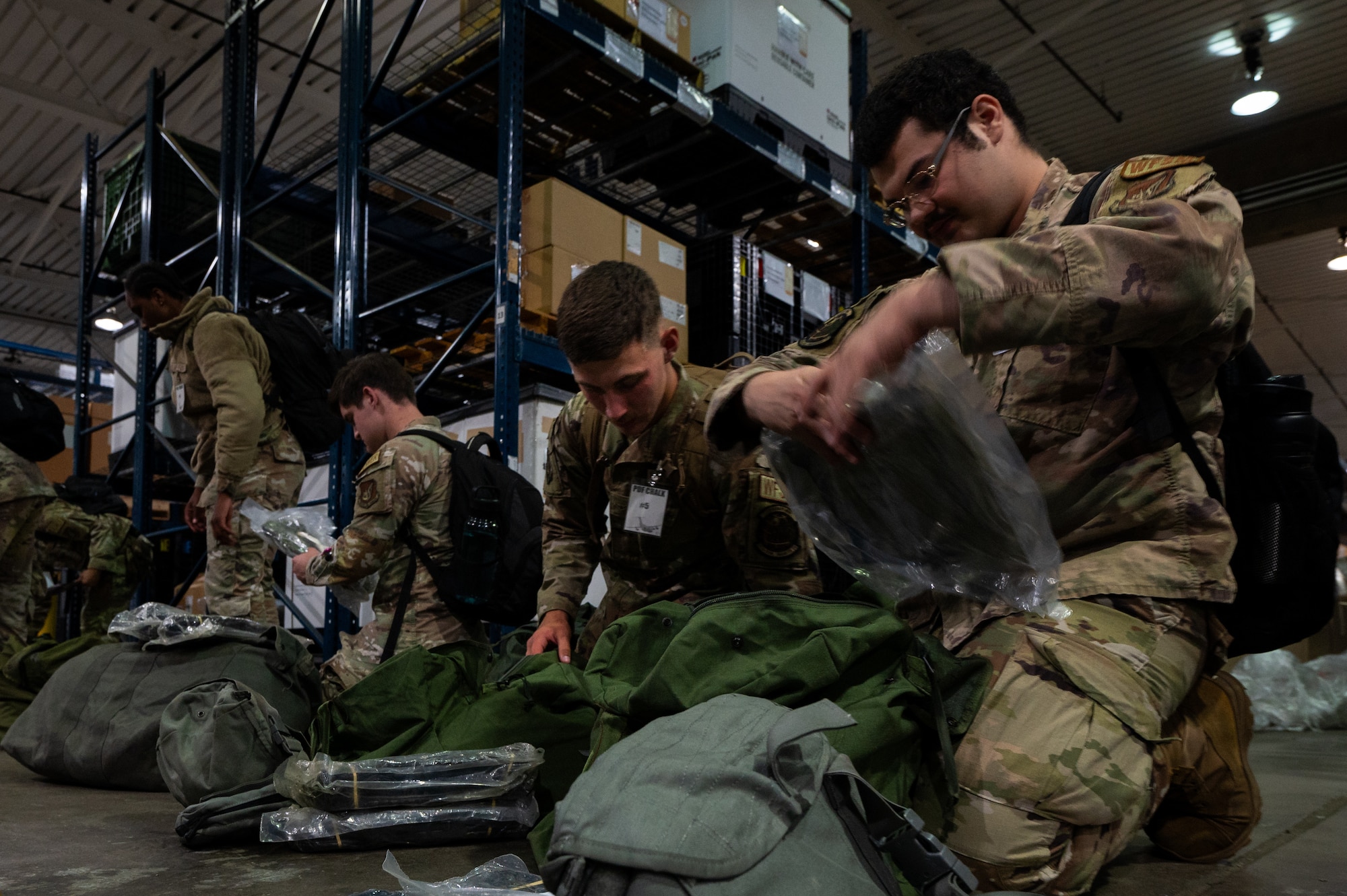 Team Hickam personnel check mobility bags at a pre-deployment function line during Agile Reaper 24-1 on Joint Base Pearl Harbor Hickam, Hawaii, April 4, 2024. Airmen were ensuring that all items in their mobility bags included all parts for their individual protective chemical, biological, radiation, and nuclear gear. (U.S. Air Force photo by Senior Airman Mark Sulaica)