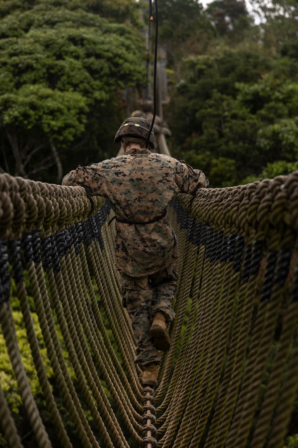 A U.S. Marine with III Marine Expeditionary Force navigates across a rope bridge during a Basic Jungle Skills Course at the Jungle Warfare Training Center on Camp Gonsalves, Okinawa, Japan, April 9, 2024. BJSC teaches Marines basic jungle survival skills, tactical rope suspension techniques, and jungle warfare tactics to enhance lethality in harsh jungle environments. (U.S. Marine Corps photo by Lance Cpl. Manuel Alvarado)