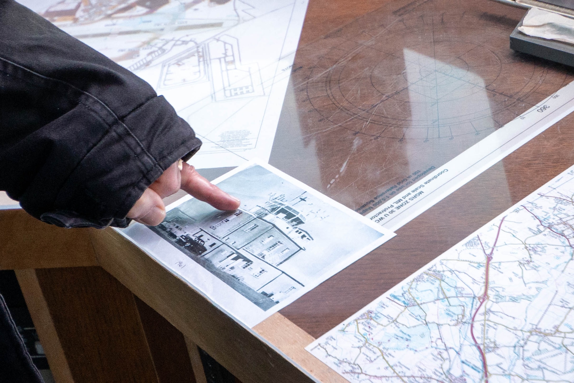 A Greenham Common control tower volunteer points to an old photo.