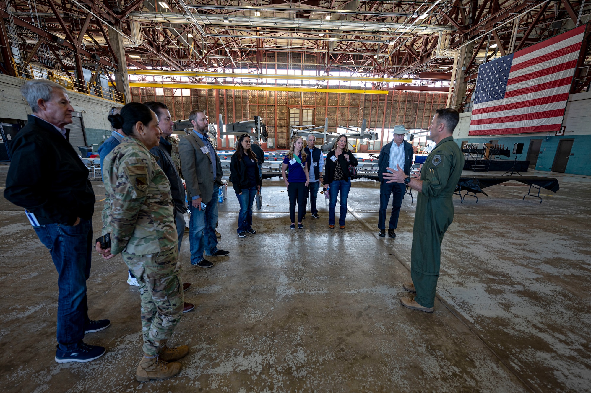 people stand together listening to a person talk