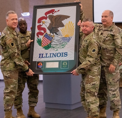 Lt. Col. Jason Celletti, second from right, Commander, 1st Battalion, 106th Aviation Regiment, and Command Sgt. Maj. Anthony Stickelmaier, right, the Command Sergeant Major for 1/106th Aviation, present Maj. Gen. Rich Neely, left, The Adjutant General of Illinois, and Commander of the Illinois National Guard, and Command Sgt. Maj. Kehinde Salami, Senior Enlisted Leader, Illinois National Guard, with the Illinois state flag which was carried on the unit’s deployment to the U.S. Central Command area of responsibility.