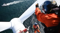 A rescue swimmer from Coast Guard Air Station Elizabeth City is lowered on to the back section of a nacelle during a search and rescue exercise (SAREX) off the coast Virginia as the marine protector-class patrol cutter USCGC Seahawk (WPB 87323) provides a safety zone, Oct. 17, 2023. The goal of the unique training was to identify challenges, understand limitations, and develop solutions to uphold our commitment to search and rescue and safety at sea. (U.S. Coast Guard Photo by Petty Officer 2nd Class Ryan L. Noel)