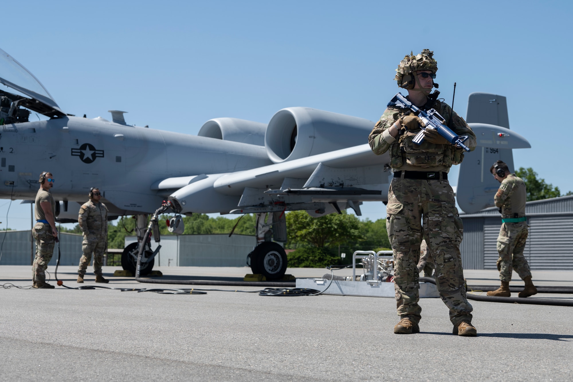 U.S. Air Force Master Sgt. David Peters, 74th Fighter Generation Squadron first sergeant and Contingency Location Perry-Houston commander, provides security for an A-10C Thunderbolt II during a refuel operation at Perry-Houston County Airport, Georgia, April 12, 2024. During Exercise Ready Tiger 24-1, Airmen from various Air Force specialties assumed roles outside of their primary duties to minimize military presence when operating at dispersed locations. During Ready Tiger 24-1, the 23rd Wing will be evaluated on the integration of Air Force Force Generation principles such as Agile Combat Employment, integrated combat turns, forward aerial refueling points, multi-capable Airmen, and combat search and rescue capabilities. (U.S. Air Force photo by Senior Airman Rachel Coates)