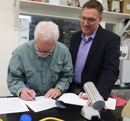 ERDC's Cold Regions Research and Engineering Laboratory (CRREL) Acting Director Dr. Ivan Beckman (right) looks on as New Hampshire Academy of Science (NHAS) Executive Director Dr. Peter Faletra signs the educational partnership agreement between the two organizations.